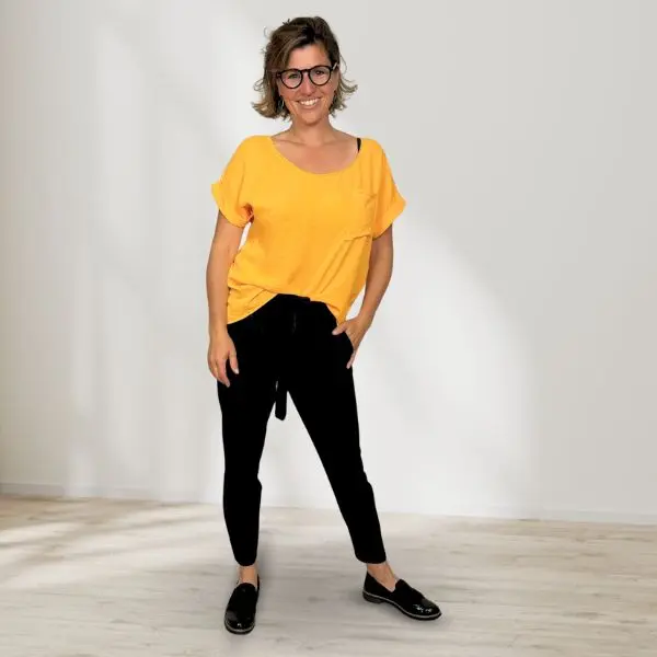 Moldel Schweiz Aline Zwahlen in einem orangen Shirt und schwarzer Hose