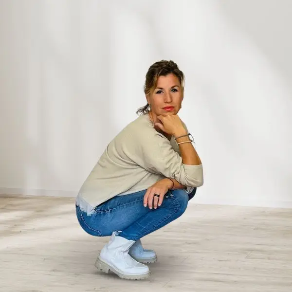 Moldel Schweiz Aline Zwahlen in einem beigen Shirt und Jeans , in der Hocke